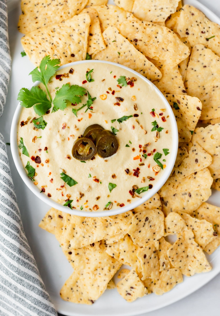 vegan queso made without nutritional yeast topped with jalapenos cilantro and chili flakes