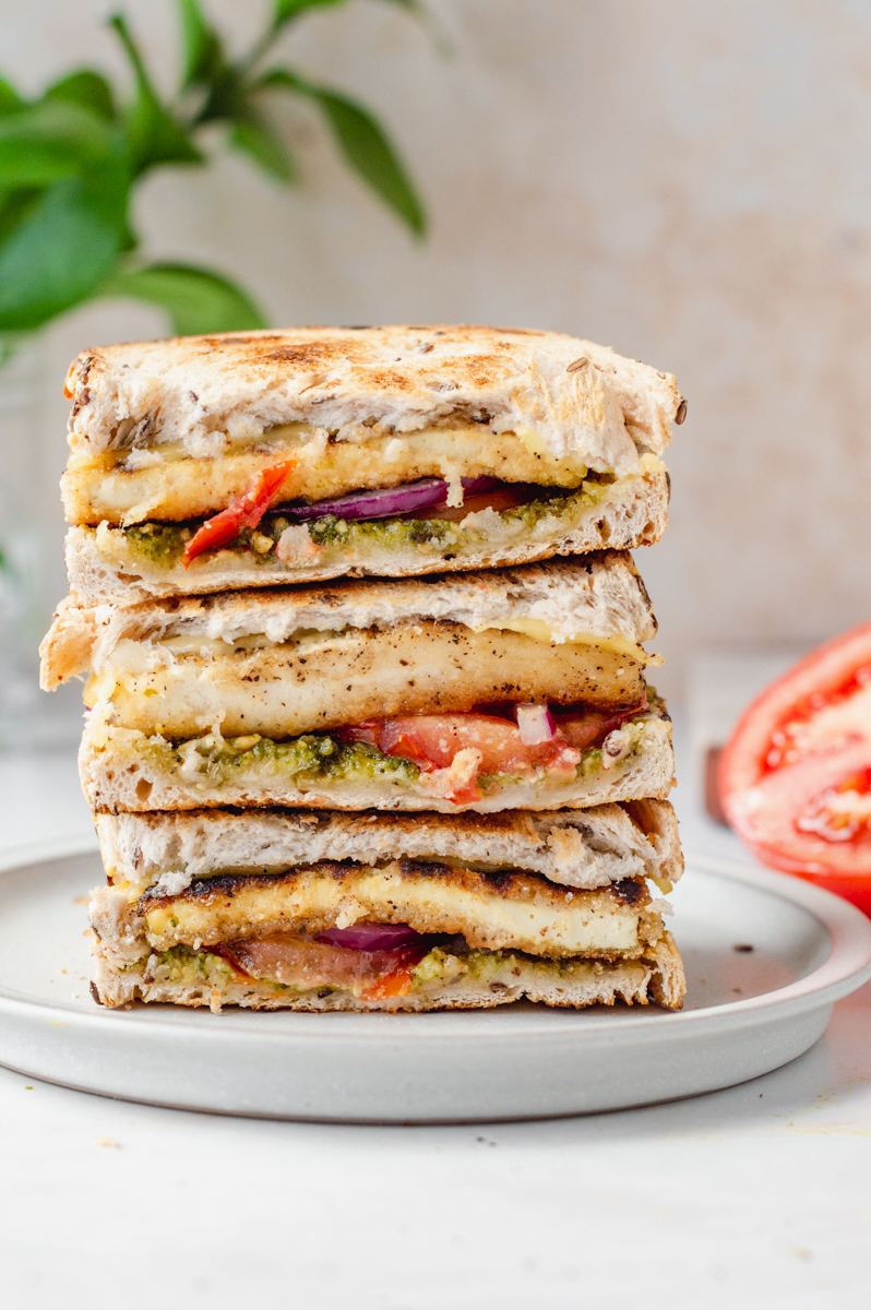 Stack of vegan smoked gouda grilled cheese with pesto and crispy tofu on gluten-free bread