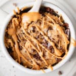 vegan peanut butter banana mug cake with chocolate chips and peanut butter drizzle