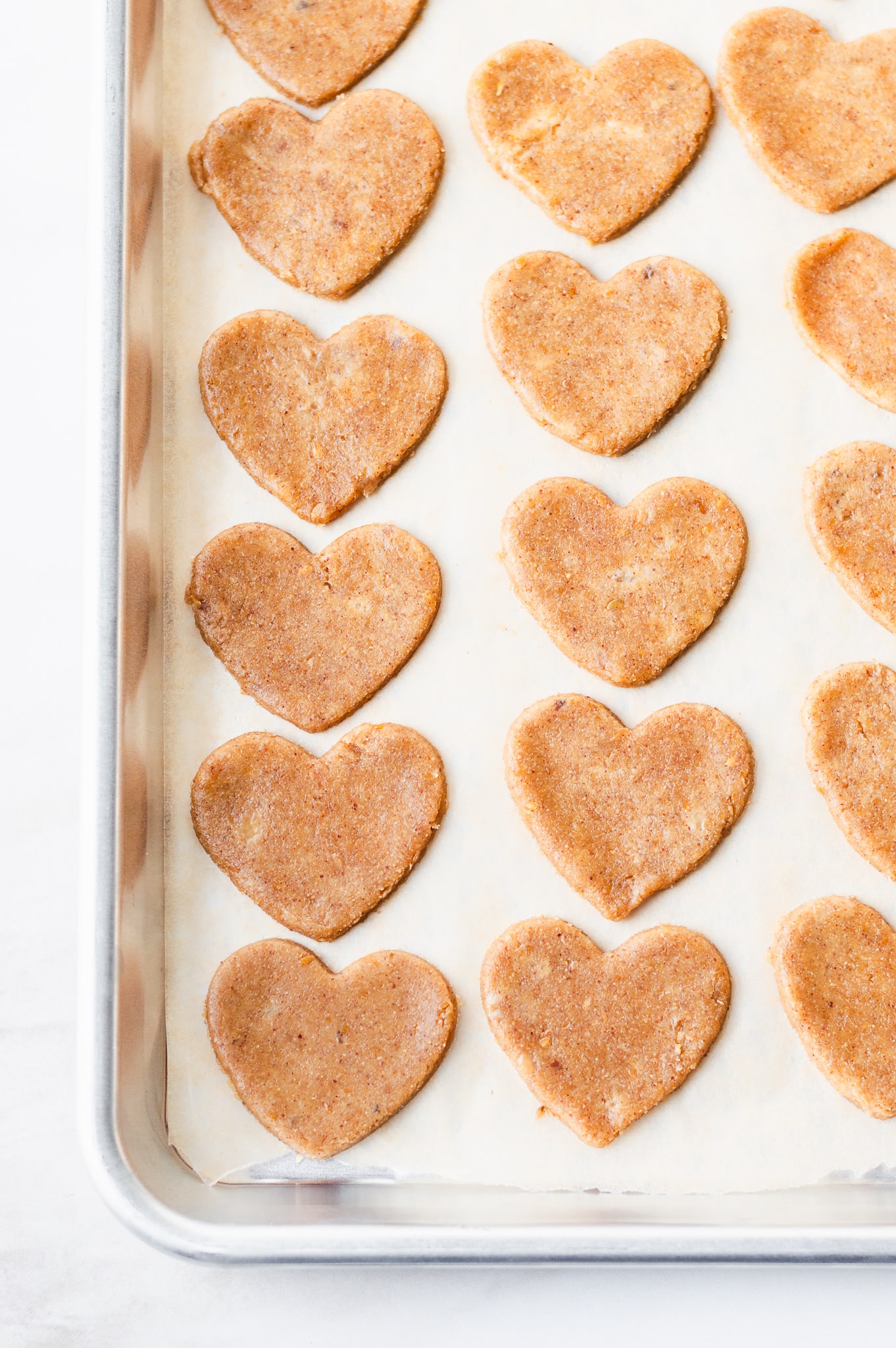 heart peanut butter dog treats on a cookie sheet