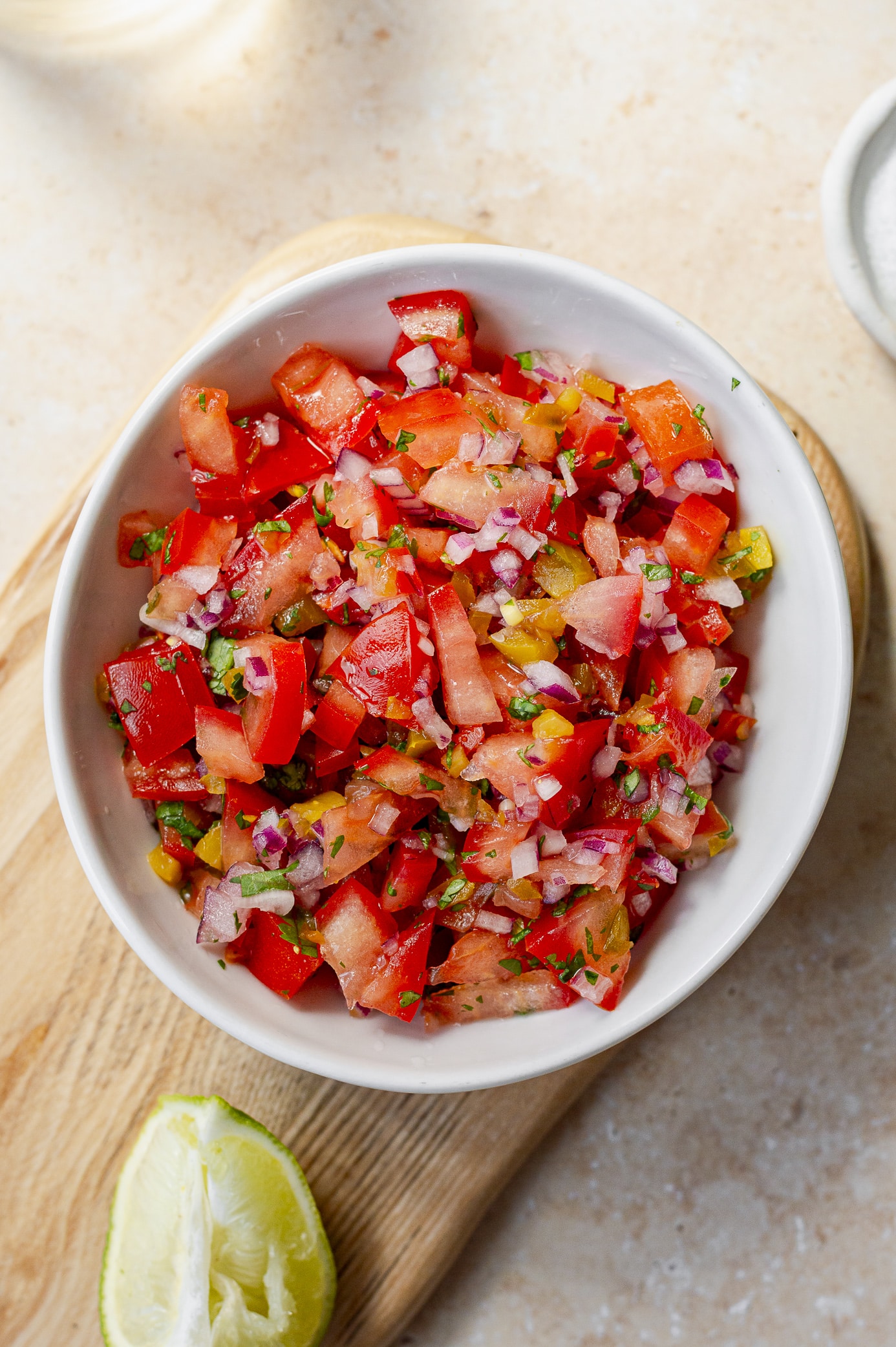 Fresh tomato salsa in a bowl with a lime wedge