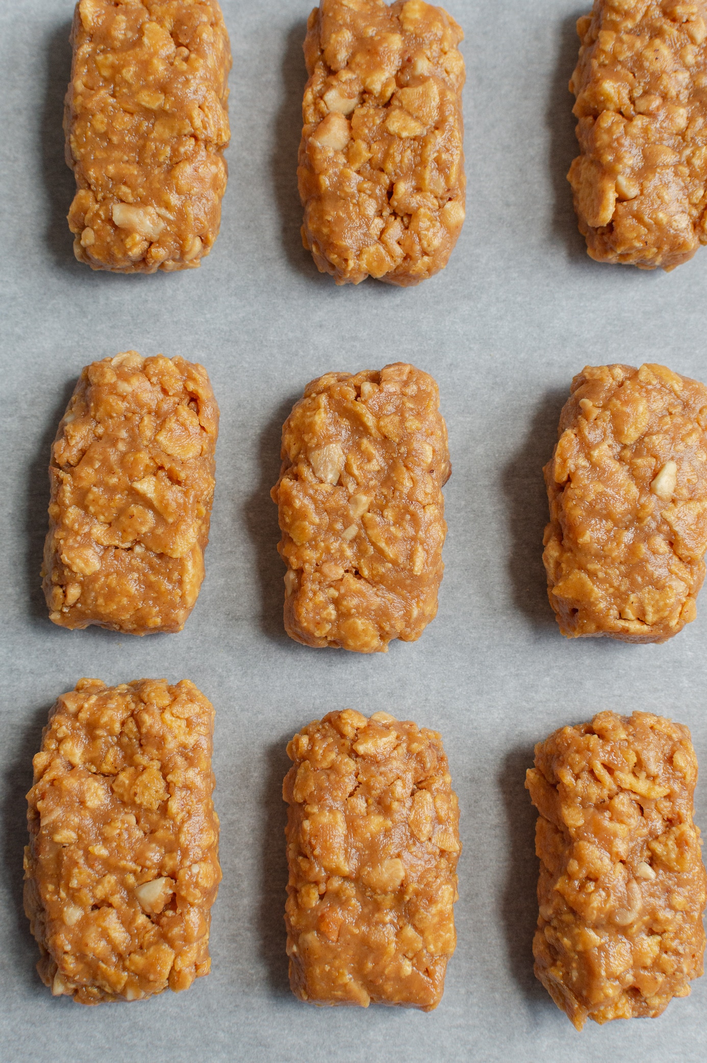 Peanut butter filling shaped into small rectangles on a parchment-lined tray