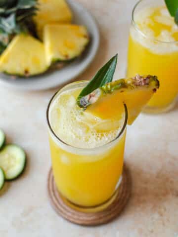Pineapple cucumber juice served over ice and garnished with fresh pineapple and pineapple stem
