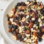 Homemade vegan trail mix with dark chocolate chunks in a speckled ceramic bowl.