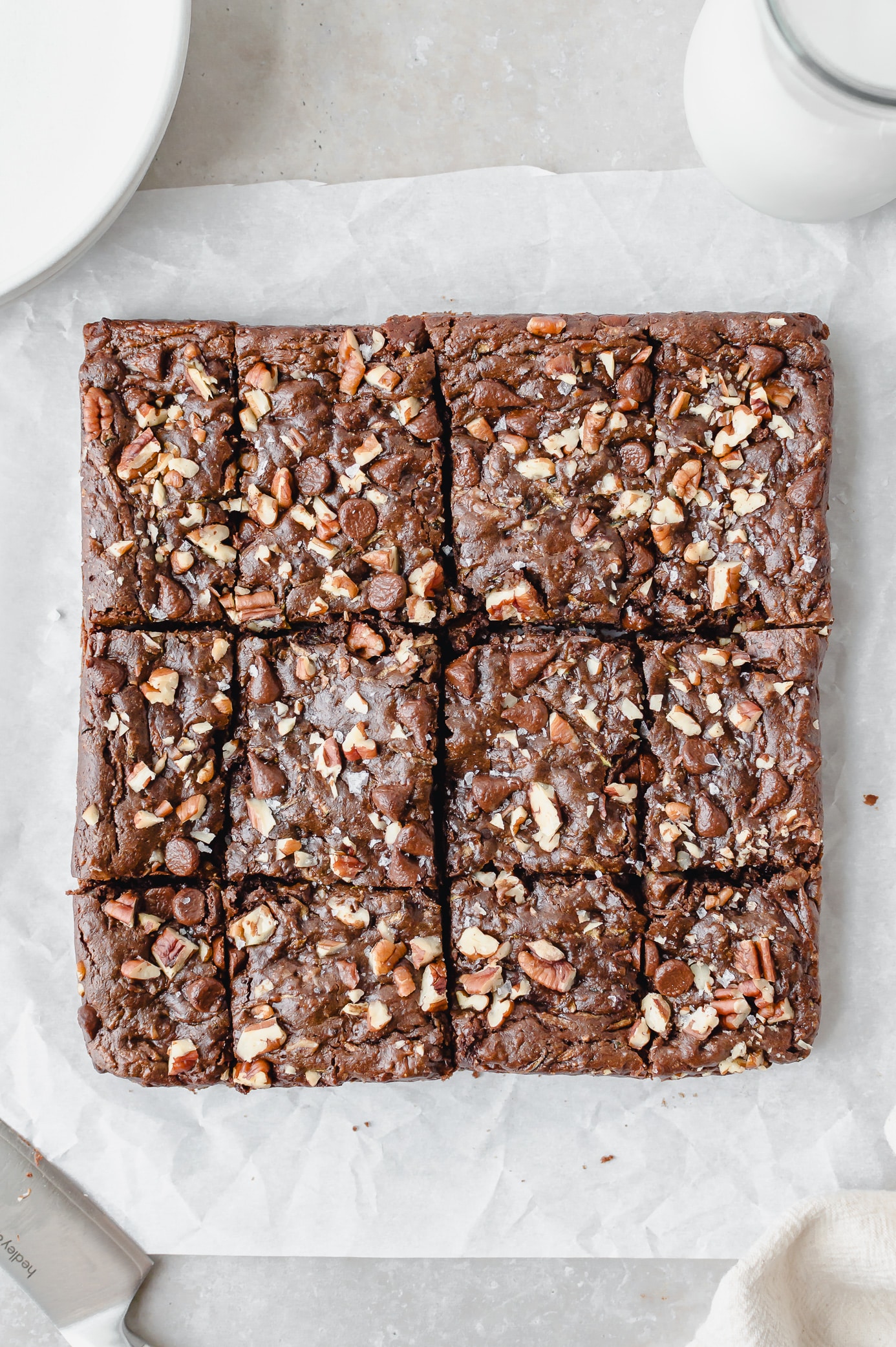 Overhead view of sliced zucchini brownies topped with chopped pecans and chocolate chips