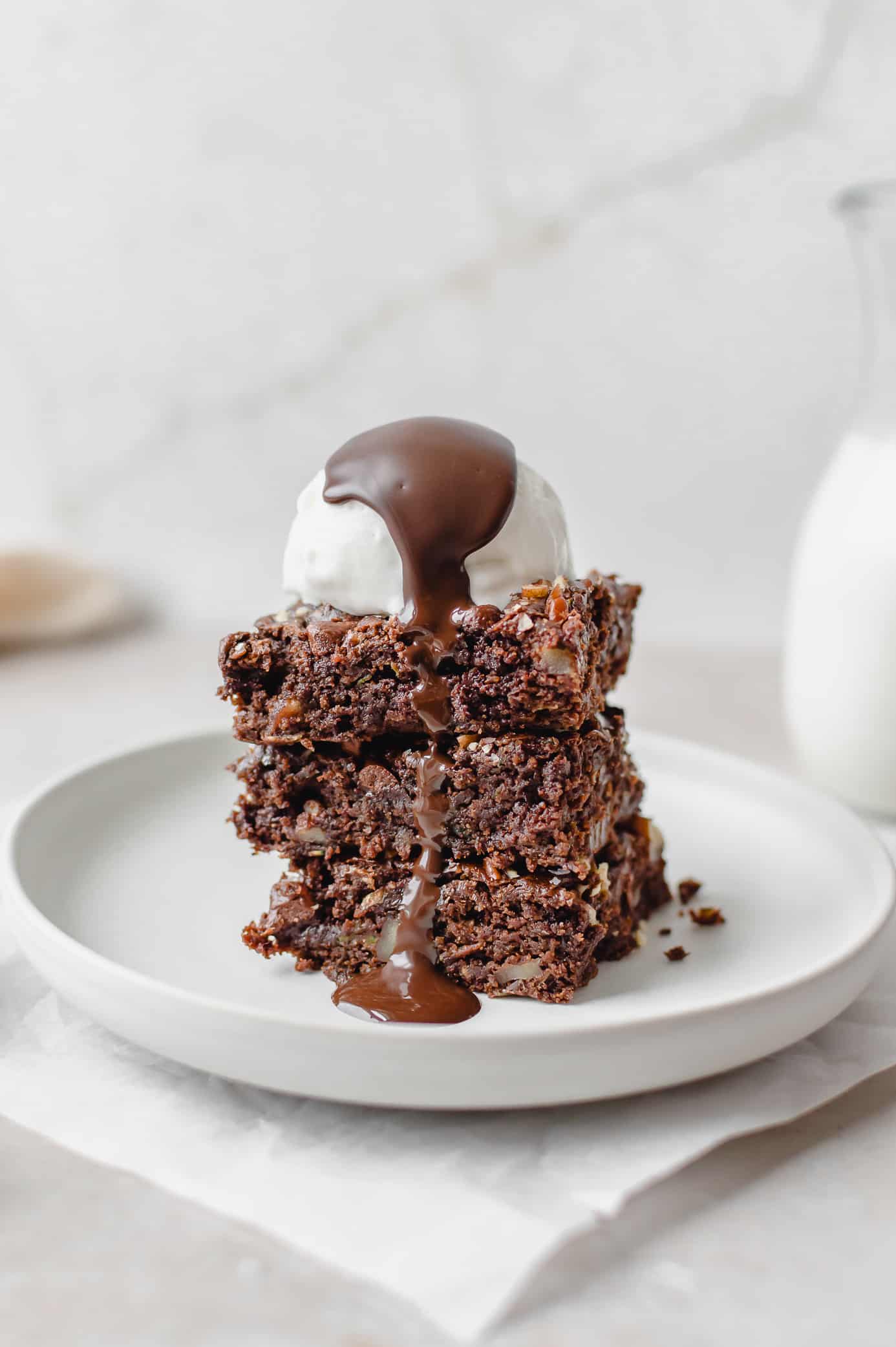 Fudgy zucchini brownie served with vanilla ice cream and chocolate drizzle