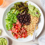 chipotle inspired veggie burrito bowl with rice, grilled veggies, salsa, and gaucamole