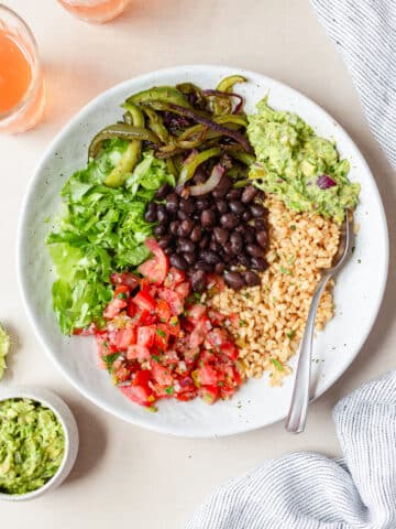chipotle inspired veggie burrito bowl with rice, grilled veggies, salsa, and gaucamole