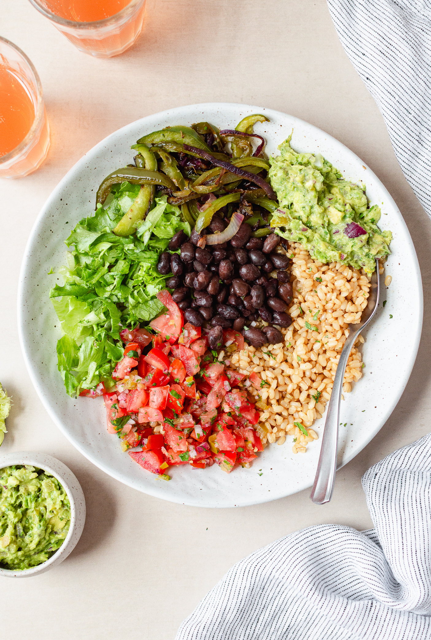 chipotle inspired veggie burrito bowl with rice, grilled veggies, salsa, and gaucamole