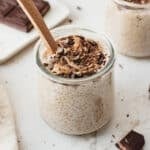 Cookie dough chia pudding in a glass jar topped with chopped dark chocolate and cashew butter