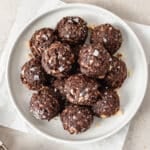 date brownie bites topped with flaky sea salt on a white plate